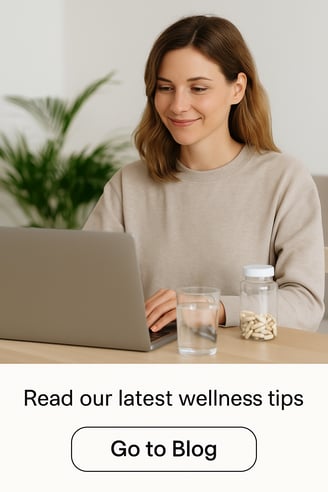 woman working on laptop with natural supplements and water on desk, exploring wellness tips online