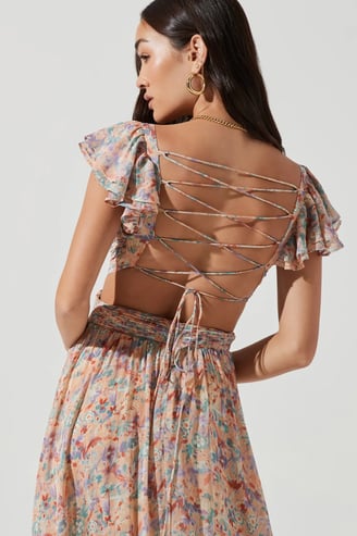 a woman wearing a floral dress with a backless top