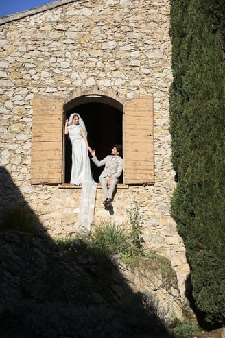 mariée et marié debout devant un bâtiment en pierre rustique, moment intime