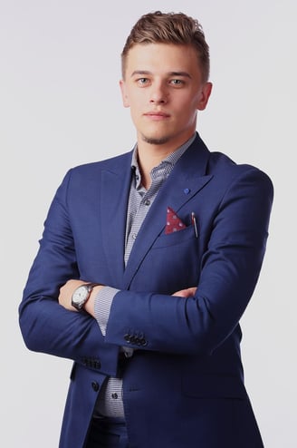 Young lawyer dressed in a sharp navy blue suit, with arms crossed, representing expert legal services in Spain.