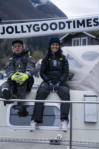 two people sitting on a boat and smiling happy | Jolly Good Times Sailing in Norway