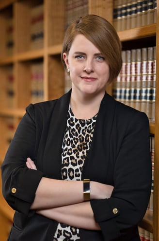 a woman in a leopard print dress and a black blazer jacket in library