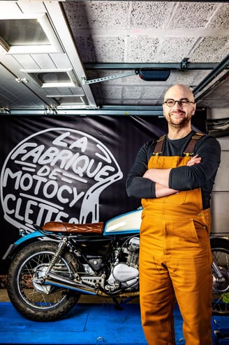 un homme en bleu de travail et en bleu de travail devant une moto