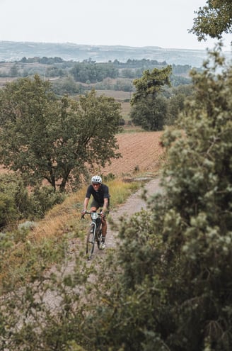 a man riding a bike down a dirt road