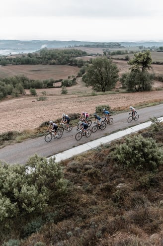 a group of cyclists riding down a road