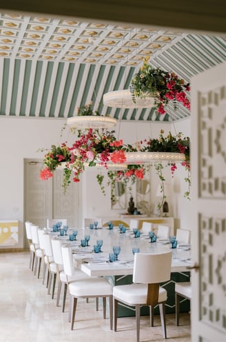 Dining room at Villa El Rincon featuring ornate ceilings with hanging lights and floral decorations for a destination wedding