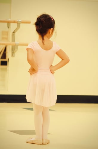 A young girl in a ballet outfit