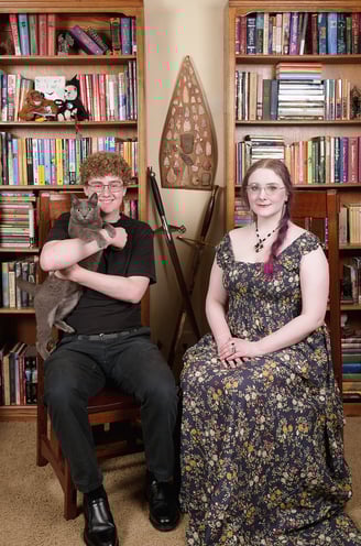 a son with a cat and a daughter sitting on a chair in a library