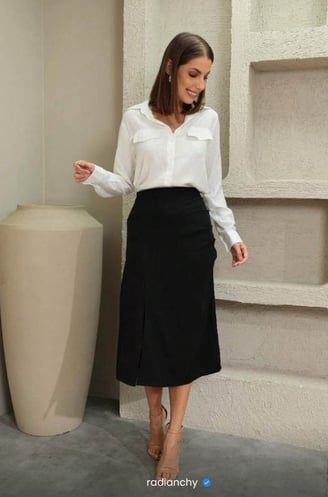 a woman in a white shirt and black skirt
