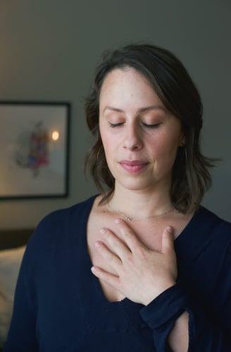 a photo of a woman with her eyes closed and hand on her chest