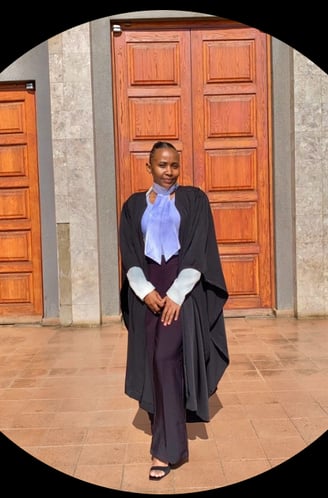 a woman in a black gown standing behind brown doors