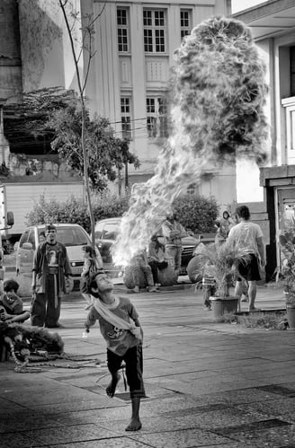 Petrol-fueled flame spitting by Indonesian boy in the lens of Peter Pickering