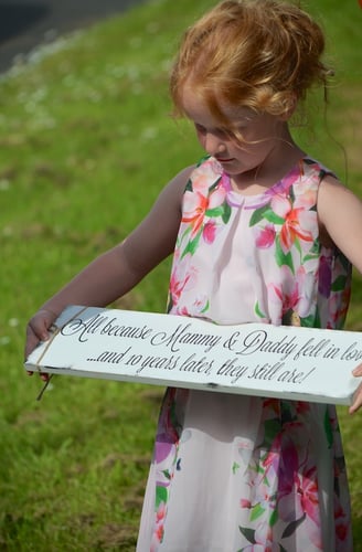 Young girl holding a sign for Mommy & Daddy
