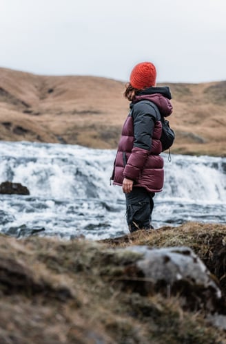 a person standing on a hill with a backpacker