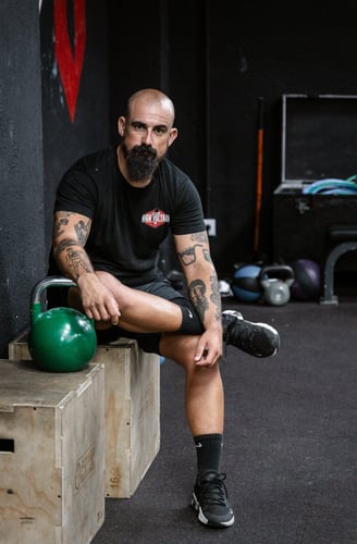 a man with a beard and a beard sitting on a bench