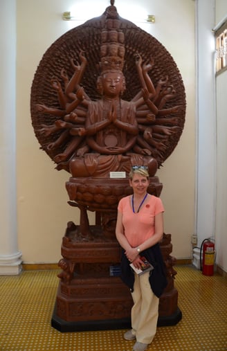 Lady Michelle poses in front of a wooden sculpture at the history museum, Ho Chi Minh City, Vietnam