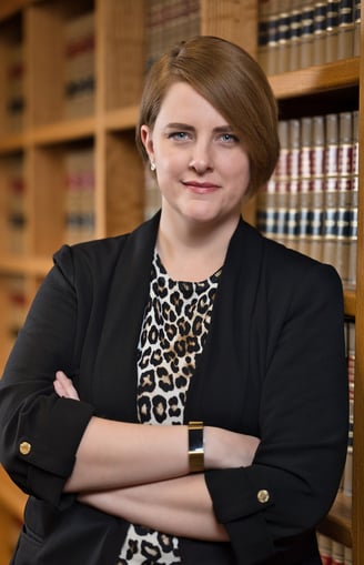 a woman in a leopard print dress and a black blazer jacket in library
