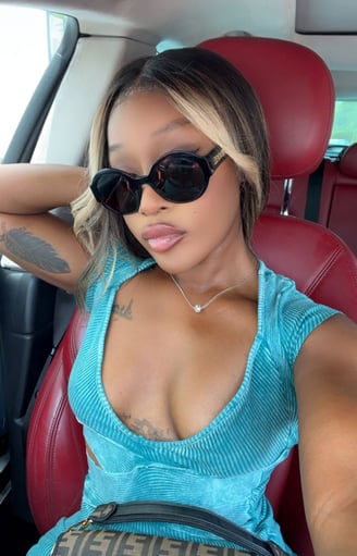 Efia Odo in a car wearing black sunglasses.