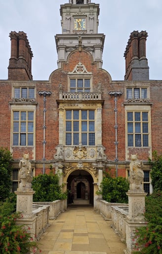 Red brick wall of mansion with chimneys