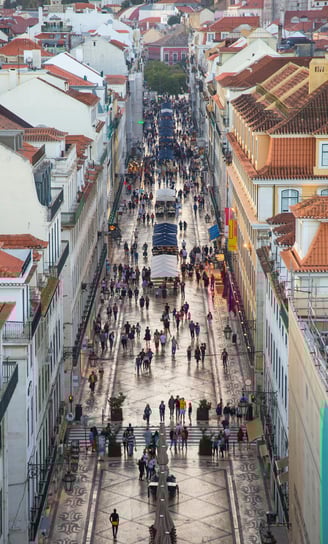a city street scene with a horse drawn carriage and people walking down the street
