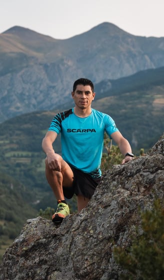 a man in a blue shirt is sitting on a rock
