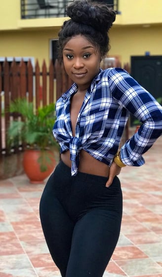 Efia Odo posed in stripped shirt with black leggings.
