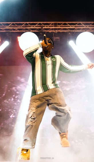 Stonebwoy in tattered jeans performing on stage.