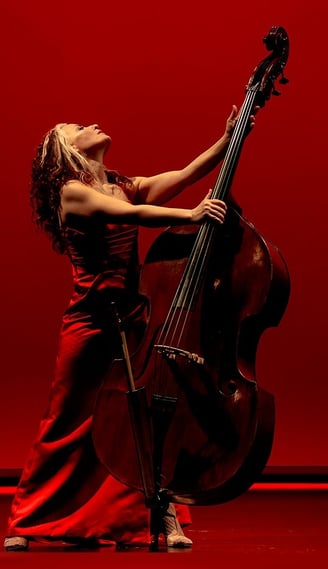 a woman in a red dress playing a doublebass