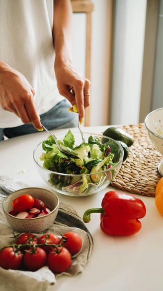 une femme prépare une salade dans un saladier