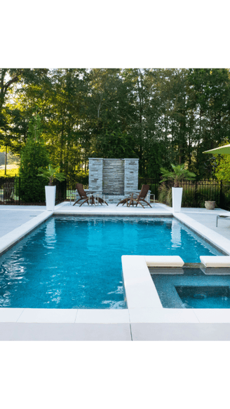 Horizontal image of a backyard setting featuring a ground-level pool and spa set-up.