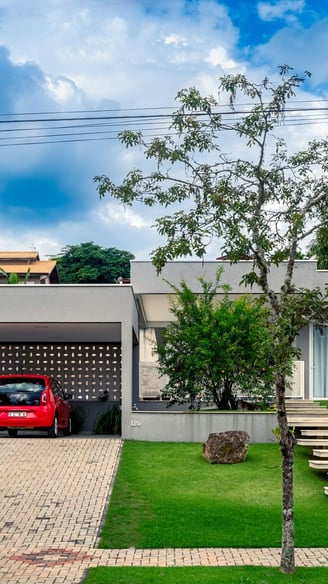 fachada cinza de casa contemporânea e carro vermelho