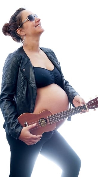 Photo de grossesse fun et dynamique avec la future maman en blouson de cuir et un ukulélé