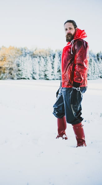 FTSH Studios model (s) Oscar Thickk UK Fetish Model wearing red vinyl jacket, farmerrain body suit, red hunter wellies, snow