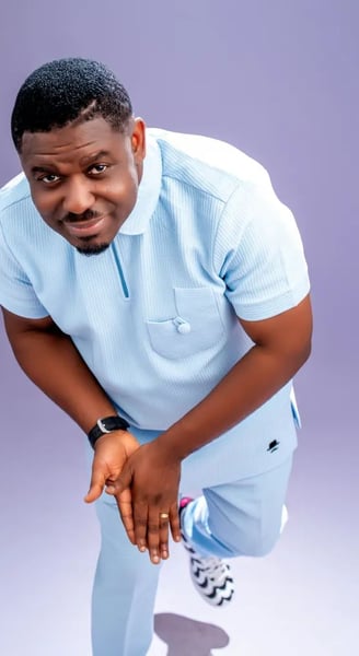 Nacee dressed in a silky blue shirt.