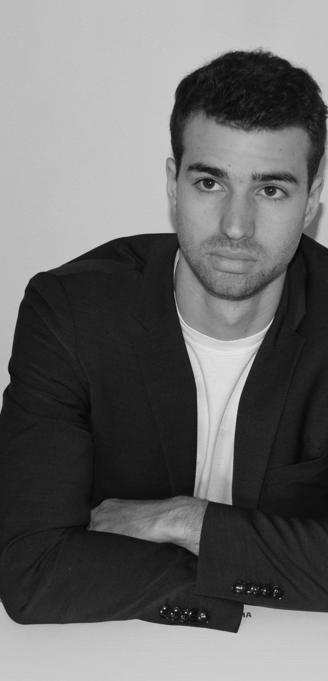 a man in a suit and tie sitting at a piano