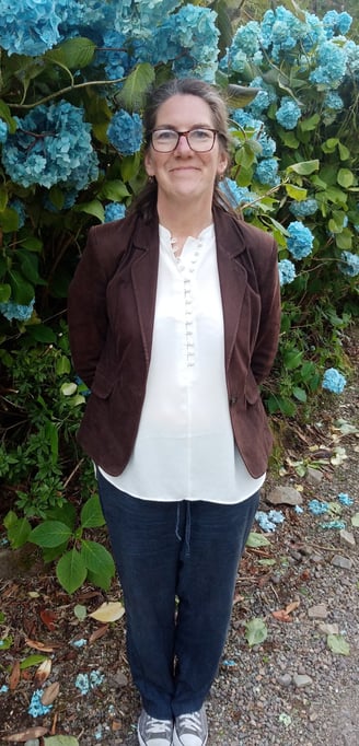 Picture of Jenny Leeder with flowers behind her