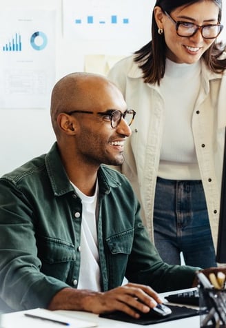 a man and woman working on a computer