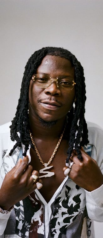 Stonebwoy in a white shirt with a golden chain.