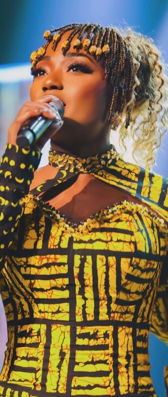 Efya Nocturnal in an African print on stage.
