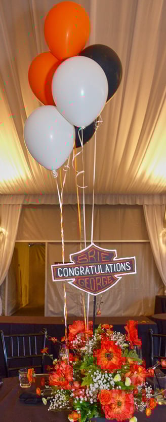 a motorcycle themed table setting with balloons and flowers