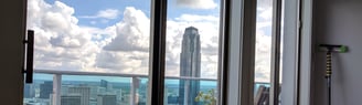 Cleaned windows from a high rise apartment overlooking the city of Houston on a bright blue day