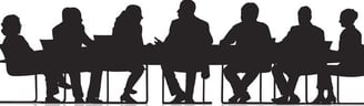 Silouhettes of people sitting at a conference table