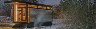 Modern prefab modular tiny home in a snowy forest setting