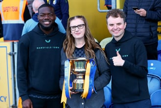 Stags defender Deji Oshilaja receives his SSA Player of the Year Award from Amy Bennett and Daniel Harris.