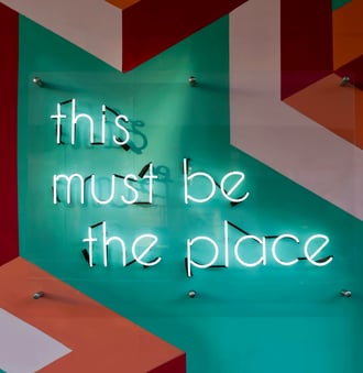 Neon sign saying this must be the place symbolizing reliable website development at Braske Agency