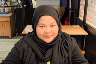 Female in black shirt and hijab in a cafe
