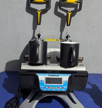 two magic mugs siting on a mug press