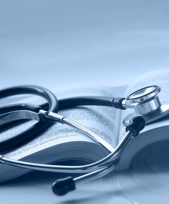 An open medical book with a stethoscope on top of it