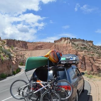 Photo of our family Adventure Van with 3 bikes on the back, a canoe and kayak and ski box on roof