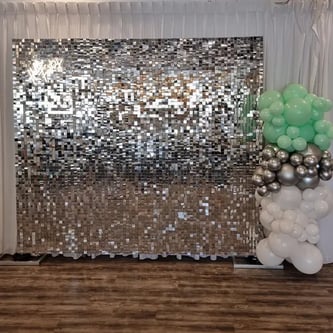 Silver shimmer wall with mint balloon garland at Fiction Bar in Cleveland, Redlands.